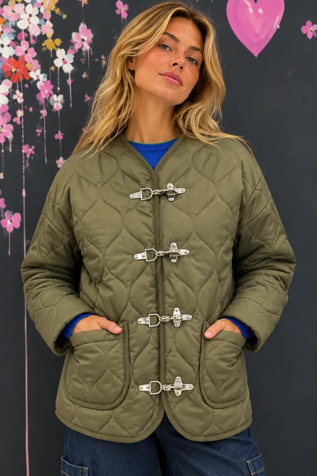 Blonde in Quilted Olive Jacket Against Mural Giacca trapuntata verde militare - immagine 1