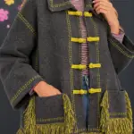 Cardigan with toggle fastenings and fringes
